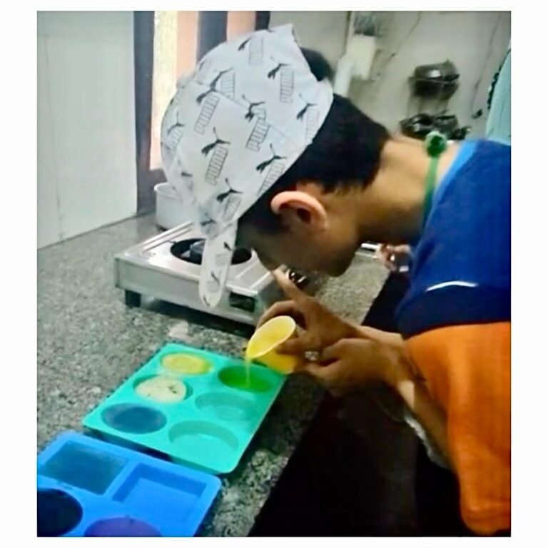 A young adult pouring into moulds during a Hunar session